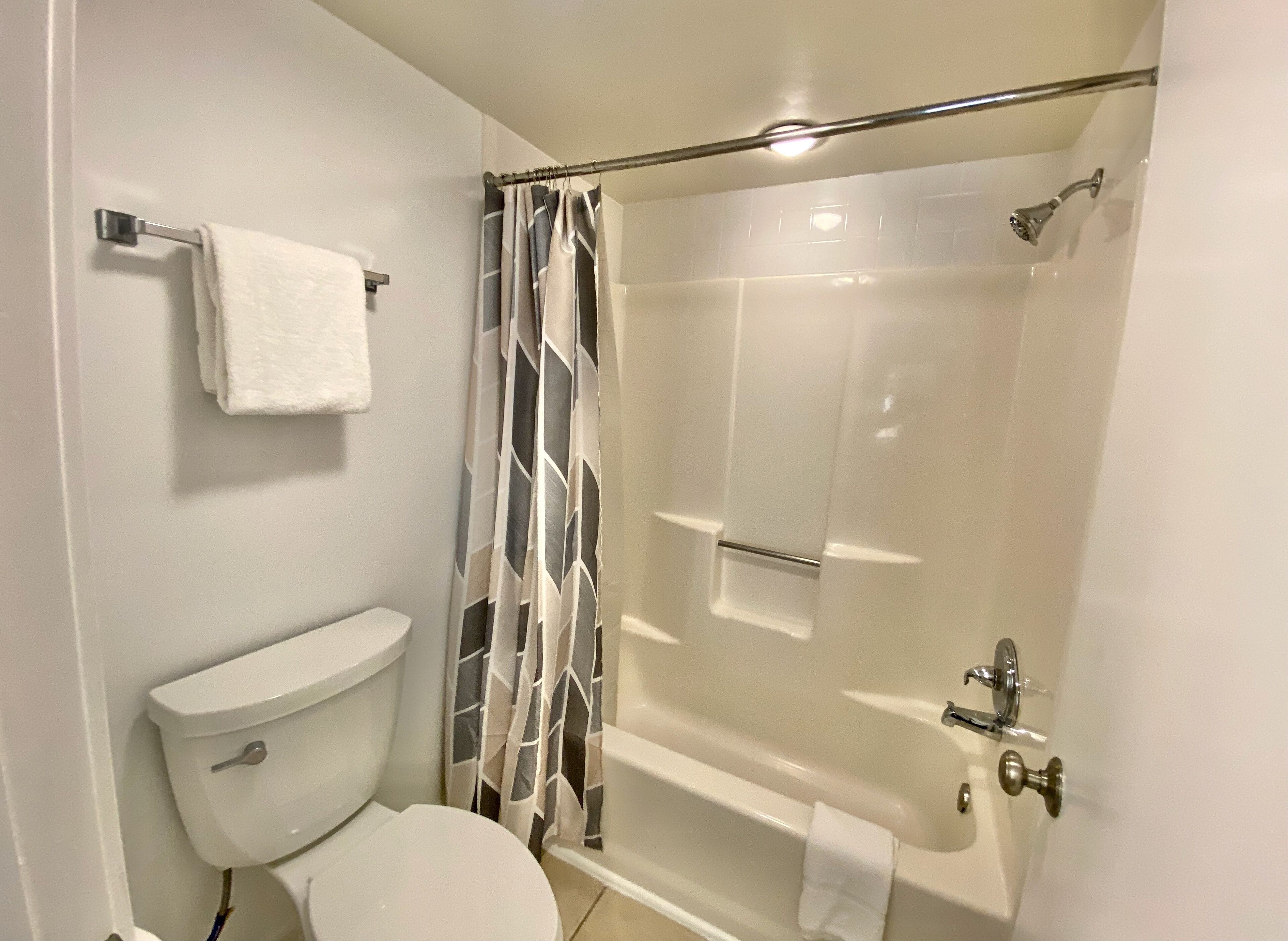 Une salle de bain comprenant des toilettes, une douche avec une porte en verre et une baignoire.