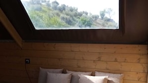 Una habitación acogedora con techo inclinado y un tragaluz grande.