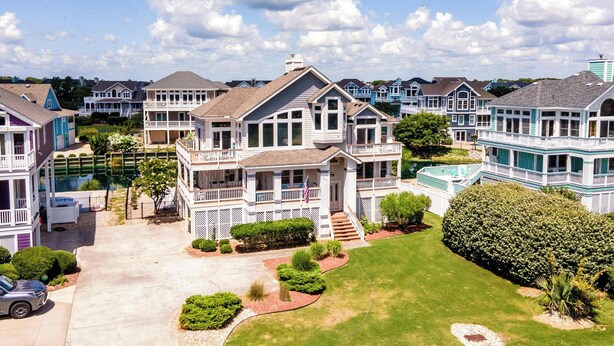 A coastal residential area with multiple two-story houses featuring balconies and large windows.