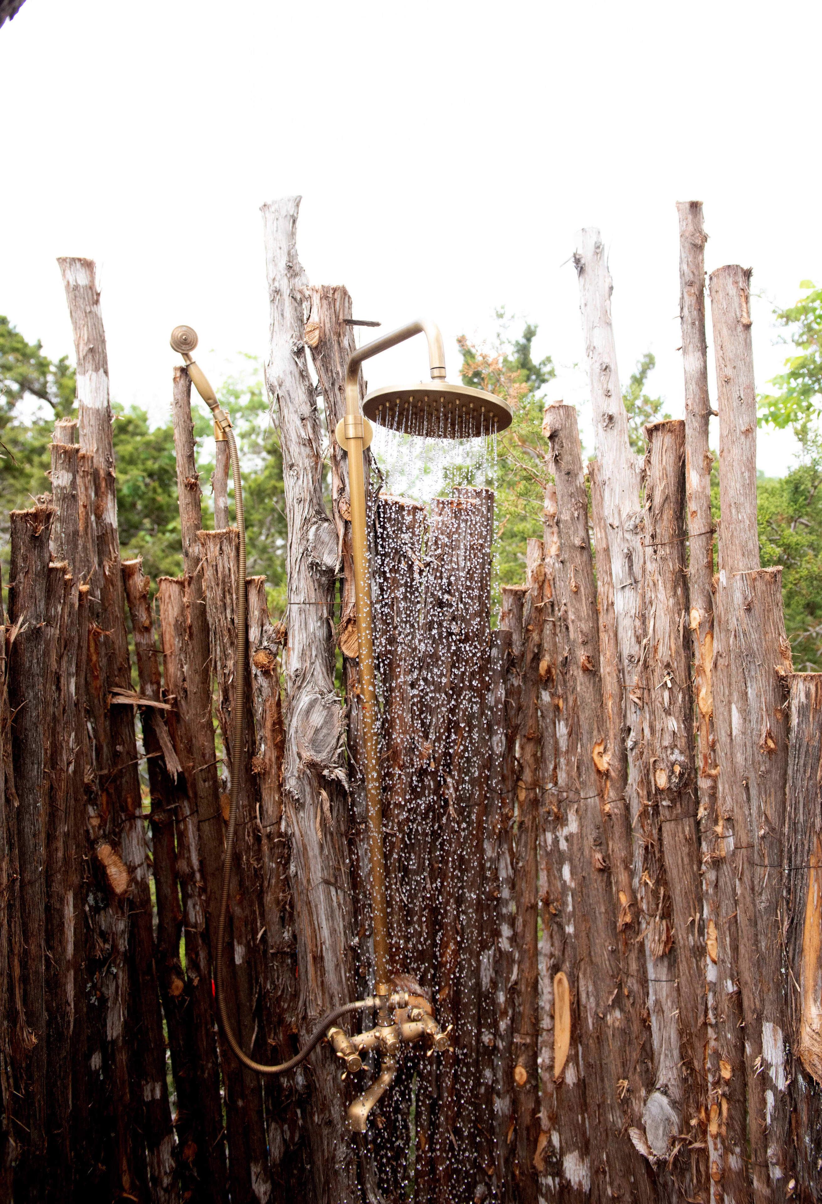 Une structure rustique en bois, dotée d’un tuyau m étallique et d’un tuyau d’arrosage, probablement utilisée pour la collecte de l’eau ou l’irrigation.