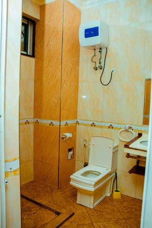 Bathroom features a toilet, sink, and shower curtain.