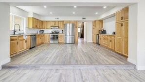 A spacious kitchen with wooden cabinets, stainless steel appliances, and a light wood floor. - Furnished Patio! Family-friendly Retreat in Tempe (Tempe)