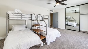 A room with bunk beds, a ceiling fan, and a large mirror. - Furnished Patio! Family-friendly Retreat in Tempe (Tempe)