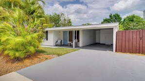 A single-story house with a covered porch, a small patio, and a wooden fence.