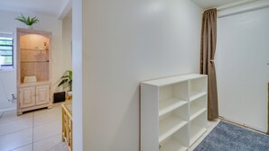 A room with a white wardrobe, a wooden cabinet, and a white shelving unit. - Vero Beach Studio w/ Shared Patio ~ 3 Mi to Beach! (Vero Beach)