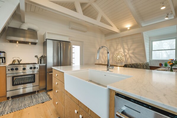 A modern kitchen with a stainless steel stove, refrigerator, and dishwasher.