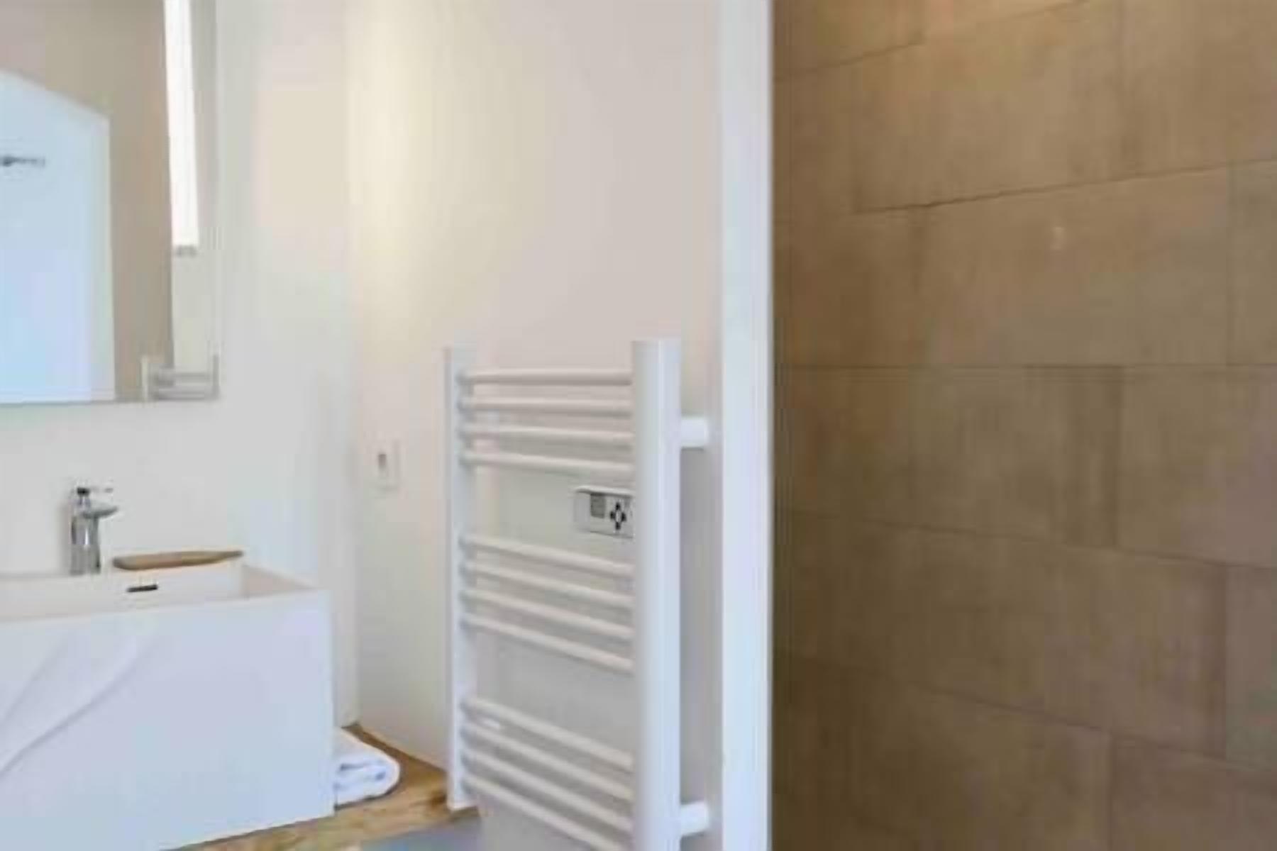 Une salle de bain avec un lavabo blanc, un miroir et un porte-serviettes.