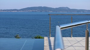 A view of a coastal area with a metal railing and a clear blue sky. - Maison Dexception les Pieds Dans Leau (Carqueiranne)