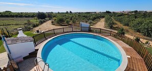 A swimming pool with a wooden deck and a view of vineyards in the background. - Quinta da Bornacha (Vila Real Santo Antonio)