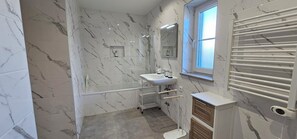 A modern bathroom with a marble backsplash, a large mirror, a sink, and a window. - Quinta da Bornacha (Vila Real Santo Antonio)