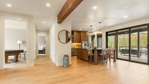 A spacious kitchen with wooden cabinets, a central island, and pendant lighting. - Quiet Neighborhood Home w/ Pristine Mountain Views (Kalispell)