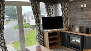 Ein modernes Wohnzimmer mit Flachbildfernseher, Kamin und einer Couch.