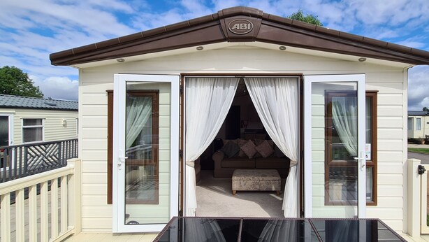 Ein Wohnmobil mit Balkon, Schiebetür und einer kleinen Veranda.