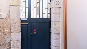 Une porte bleu foncé, dotée d’une poignée en laiton et d’un autocollant rouge, est encastrée dans un mur de pierre, au-dessus de laquelle figure le chiffre « 39 ».