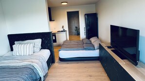 A compact room with two beds, a TV, and a kitchenette. - Ny og Moderne Studio- Leilighet ved Fetsund i Lillestrøm (Akershus)