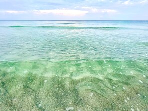 A clear view of the ocean with visible underwater terrain and a distant horizon.