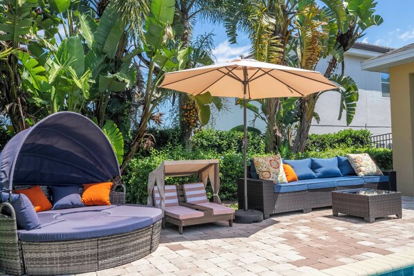 Un patio con una zona de estar circular, un sofá y una mesa.
