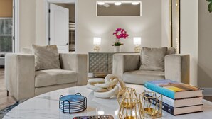 Ein modernes Wohnzimmer mit zwei Sofas, einem Couchtisch und einem Bücherregal.