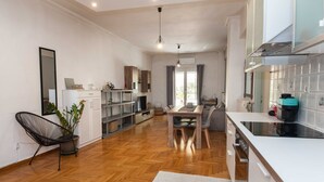 A spacious kitchen with a dining area, wooden flooring, and modern appliances. - Modern 2 Bd Kipseli Hideaway Patio Apt (Athens)