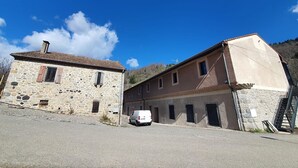 Un edificio de piedra con una furgoneta blanca estacionada frente a él.