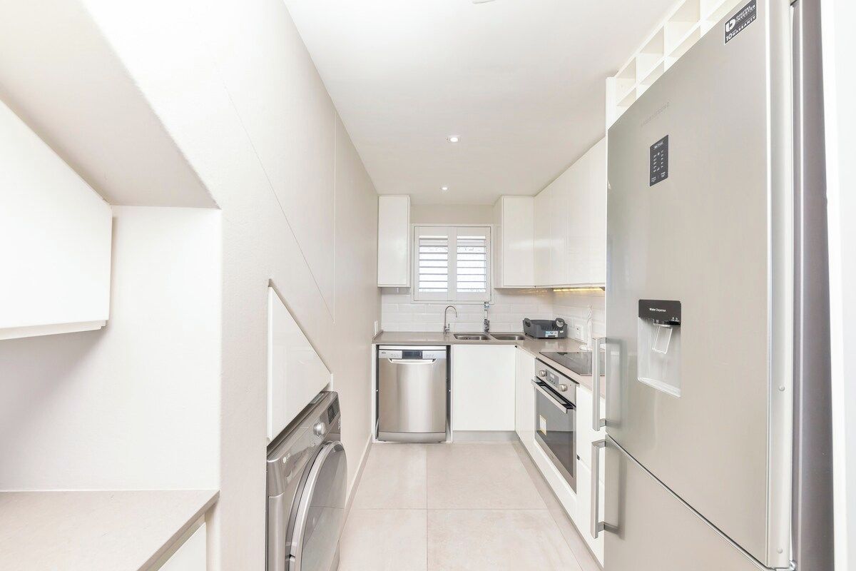 A compact kitchen with a dishwasher, oven, and a refrigerator.