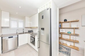 A modern kitchen with a stainless steel refrigerator, dishwasher, and oven. - Dolphin Beach H205 Beachfront Apt, blouberg by hmh (Kaapstad)