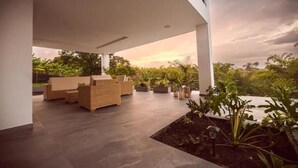 Eine Außenpatio-Terrasse mit Korbmöbeln und Topfpflanzen.