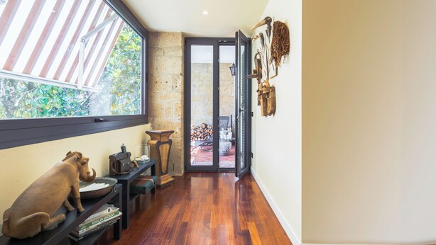 A hallway with a wooden floor, a large window, and a door leading to an outdoor area. - A Casa Di Camillo, Nepi, a C (Nepi)