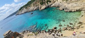 A coastal landscape with clear turquoise waters, rocky cliffs, and a sandy beach. - L'antico Ulivo - THE View (Santa Cesarea Terme)