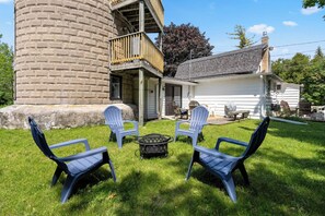 Un jardin avec une structure en briques, une terrasse en bois et un espace salon extérieur.