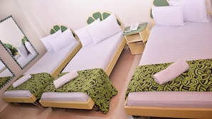 A hotel room with two single beds, a double bed, a bedside telephone, and a mirror on the wall. - Hotel Business (Bogotá)