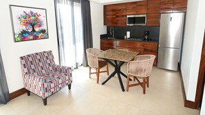 Una cocina moderna con armarios de madera, un refrigerador de acero inoxidable y un comedor con mesa y sillas.