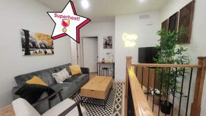 A modern living room with a sofa, coffee table, and a staircase.