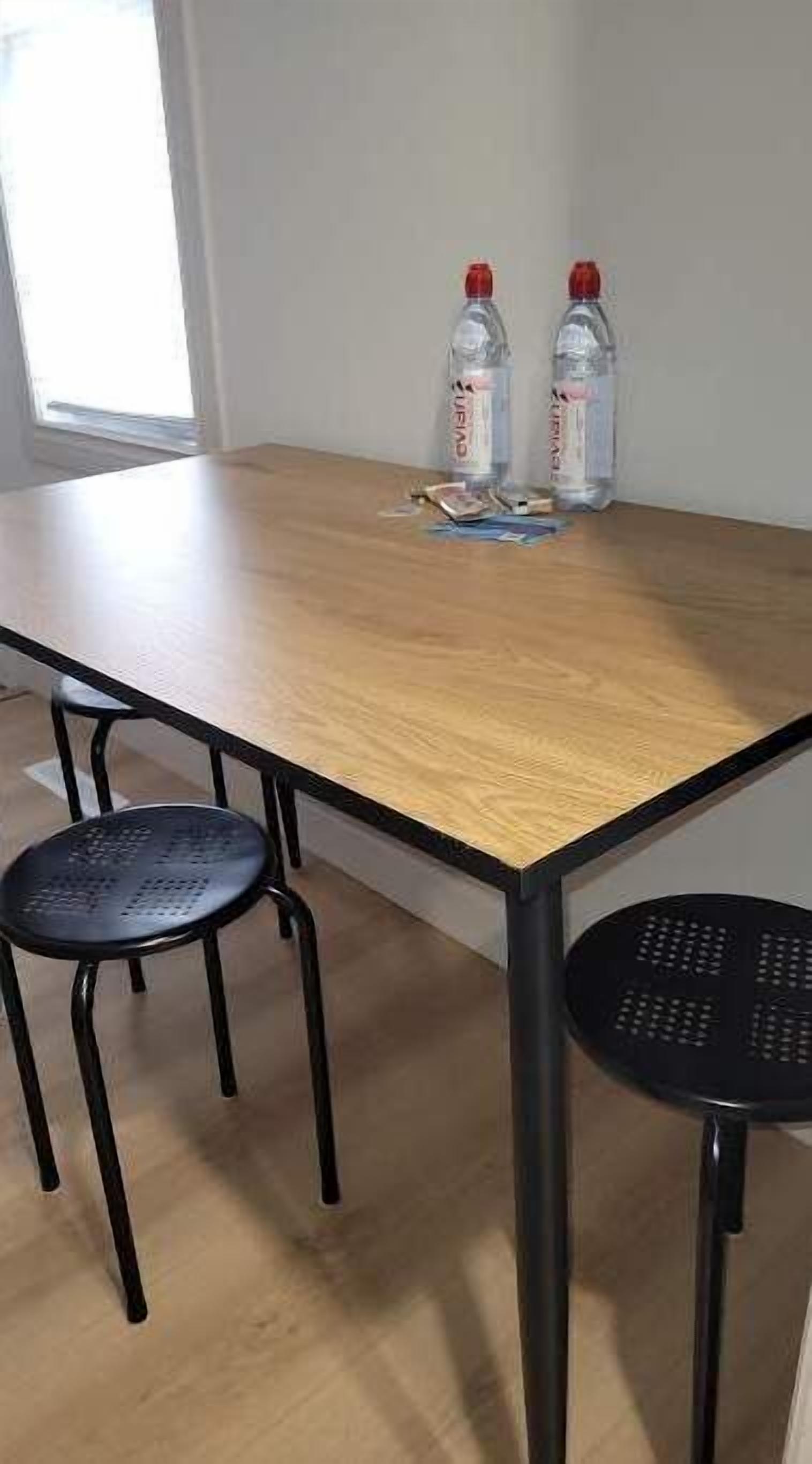 A conference table with two chairs, two water bottles, and some papers on it.