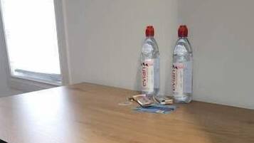 A conference table with two chairs, two water bottles, and some papers on it.
