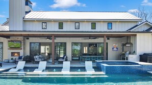 Ein modernes Haus mit Swimmingpool, Sitzgelegenheiten im Freien und einer Grillzone.