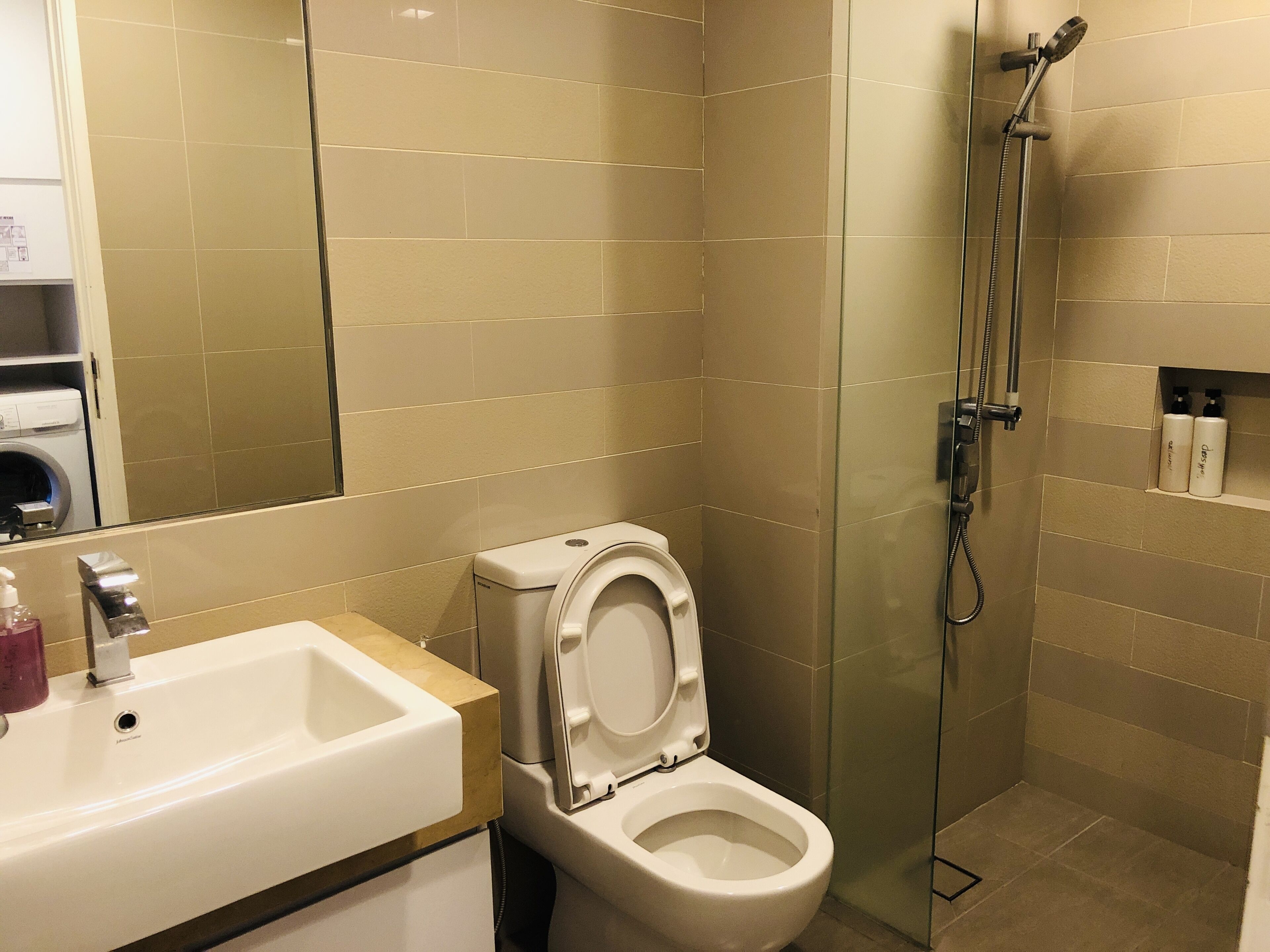 A modern bathroom with a toilet, sink, and shower.
