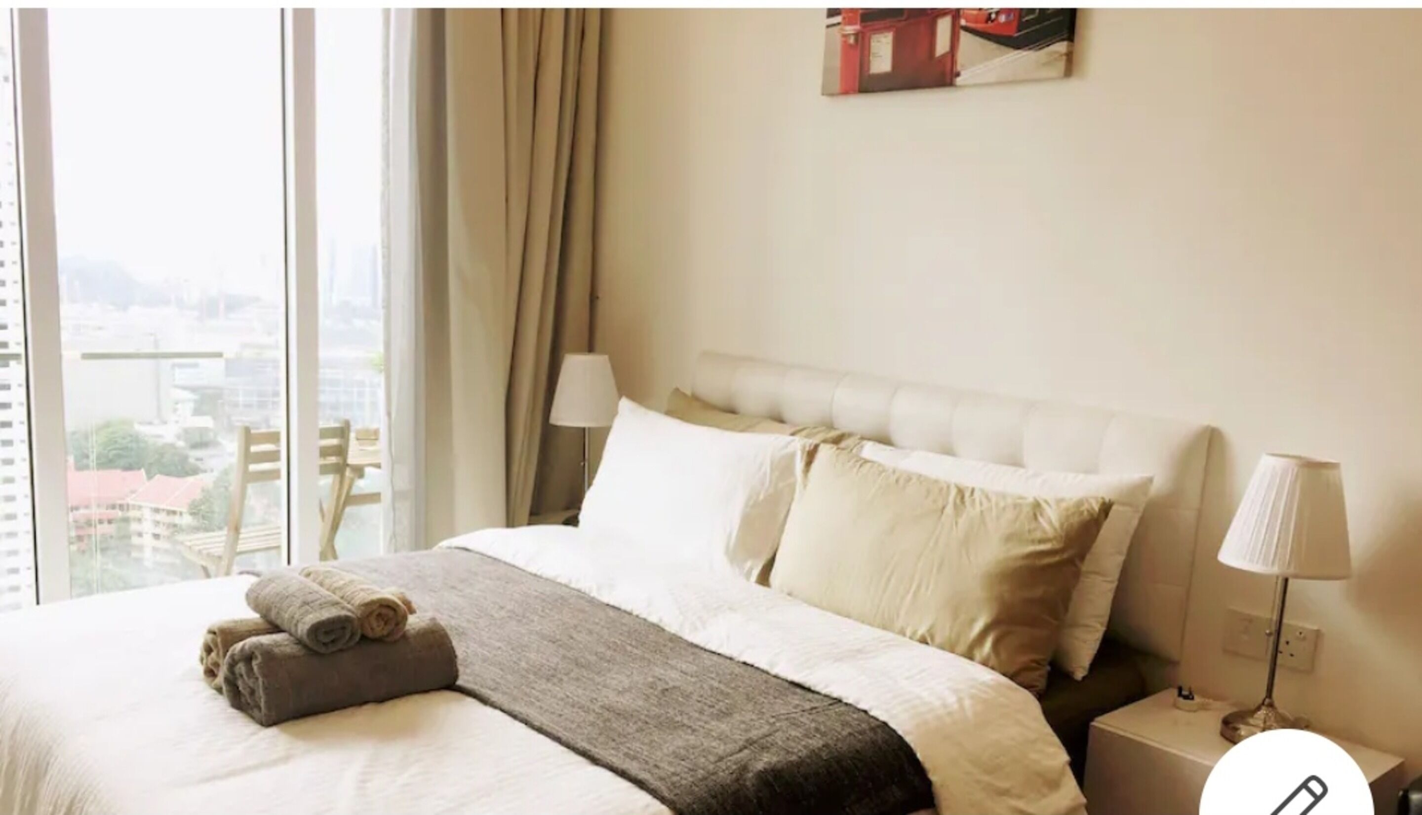 A hotel room with a large bed, a view of the city, and a window with curtains.
