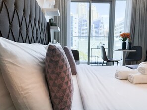 Relax in a stylish room with a large bed, desk, and city view.