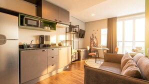 Una cocina moderna con microondas, cafetera y comedor con mesa y sillas.