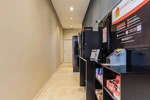 A corridor with a self-service kiosk and shelves stocked with snacks.