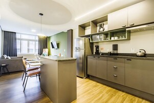 A modern kitchen with a central island, built-in appliances, and a dining area with a sofa and chairs.