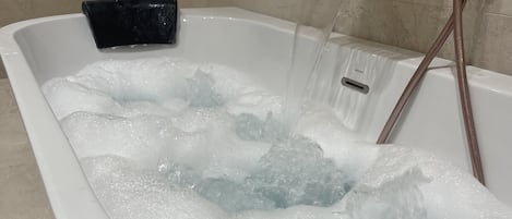 Een douche, een bubbelbad, handdoeken, zeep