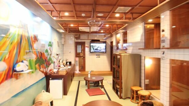 A traditional Japanese restaurant interior with tatami flooring, a television, and a sushi bar. - Cat Spa & Cat Ryokan Neco Republic Osaka (Osaka)
