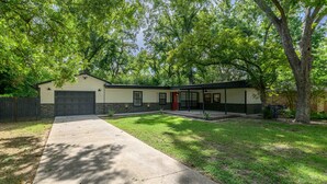 A single-story house with a garage, a front yard with grass, and a large tree. - Forest Hill Family Hideaway- 4-Bed Retreat (Dallas)