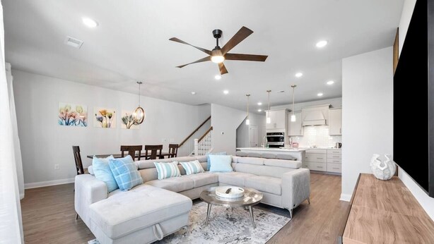 A modern living room with a sectional sofa, a coffee table, and a dining area with chairs. - Tee & Sea Paradise- Pool- Slps 11- Golf View-Grill (North Myrtle Beach)