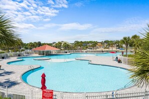A large outdoor swimming pool with multiple sections and a covered area.