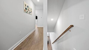 A modern interior with a wooden floor, white walls, and a staircase with a wooden handrail. - Tee & Sea Paradise- Pool- Slps 11- Golf View-Grill (North Myrtle Beach)
