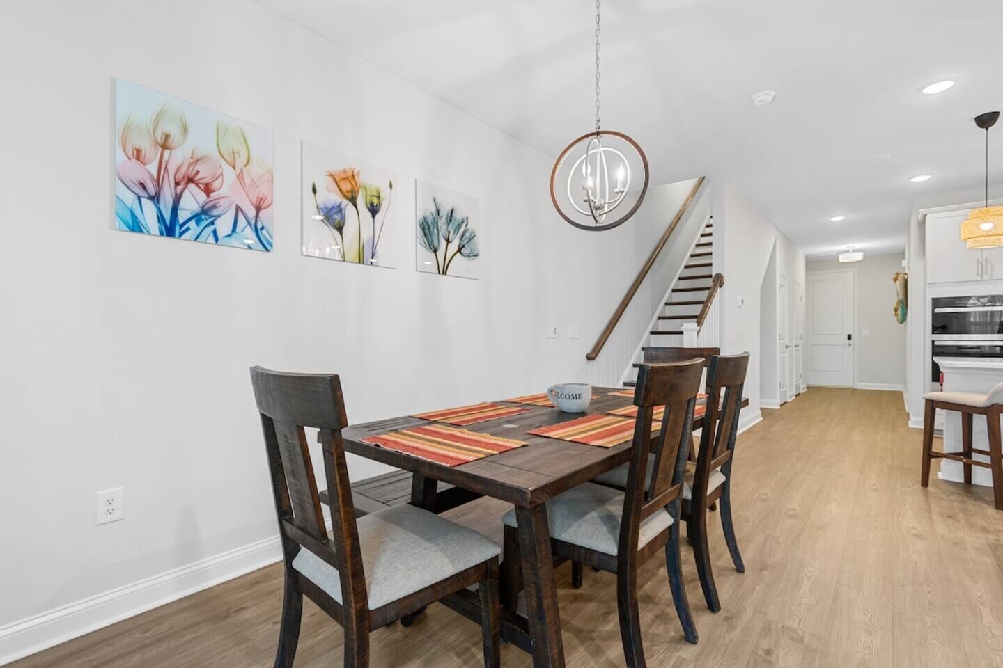 Un comedor con mesa de madera, sillas y una lámpara colgante.