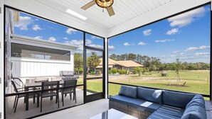 A modern outdoor living space with a patio, seating area, and a view of a residential neighborhood. - Tee & Sea Paradise- Pool- Slps 11- Golf View-Grill (North Myrtle Beach)